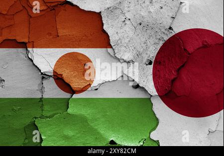 Flaggen von Niger und Japan auf gerissene Wand gemalt Stockfoto