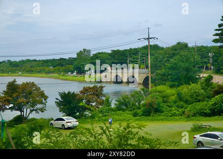 Goseong County, Südkorea - 28. Juli 2024: Ein friedlicher Blick auf den Hwajinpo See, mit einer Steinbrücke, die die Landschaft in der Nähe von Syngman Rhee's Vill verbindet Stockfoto