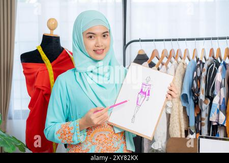 Der Besitzer eines kleinen Schneidergeschäfts stellt Kleidungsstücke vor Stockfoto