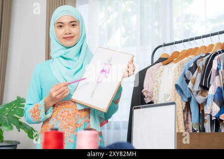 Der Besitzer eines kleinen Schneidergeschäfts stellt Kleidungsstücke vor Stockfoto