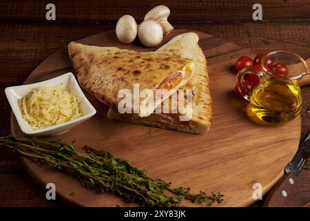 Calzone, traditionelle italienische Zubereitung, begleitet von Gewürzen und Rotwein Stockfoto