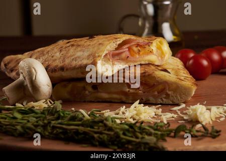 Calzone, traditionelle italienische Zubereitung, begleitet von Gewürzen und Rotwein Stockfoto