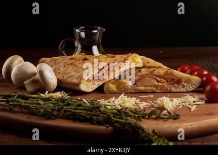 Calzone, traditionelle italienische Zubereitung, begleitet von Gewürzen und Rotwein Stockfoto