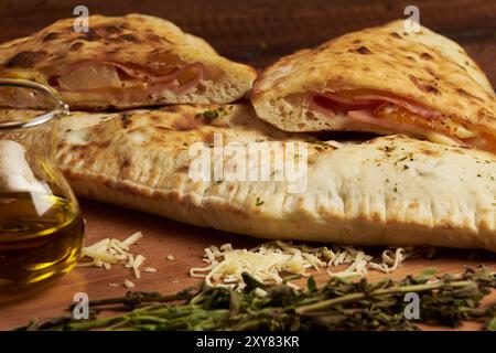 Calzone, traditionelle italienische Zubereitung, begleitet von Gewürzen und Rotwein Stockfoto