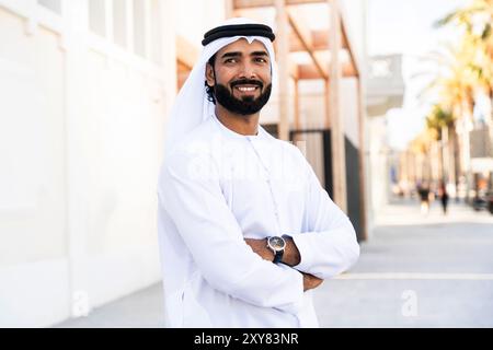Traditioneller arabischer Mann, der im Freien emirat Kandura trägt - hübsches männliches Geschäftsmann-Porträt aus dem Nahen Osten in der Stadt Stockfoto