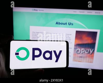 Person mit Smartphone und Logo des nigerianischen Fintech-Unternehmens Opay Digital Services Limited vor der Website. Schwerpunkt auf dem Display des Telefons. Stockfoto