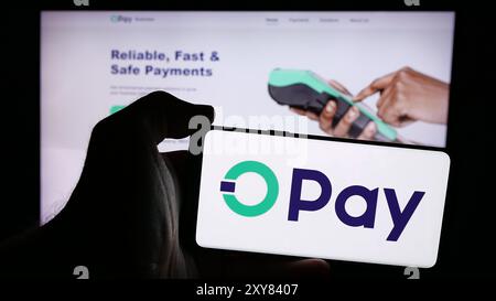 Person, die ein Mobiltelefon mit dem Logo des nigerianischen Fintech-Unternehmens Opay Digital Services Limited vor der Webseite hält. Schwerpunkt auf dem Display des Telefons. Stockfoto