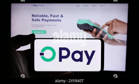 Person, die ein Mobiltelefon mit dem Logo des nigerianischen Fintech-Unternehmens Opay Digital Services Limited vor der Webseite hält. Schwerpunkt auf dem Display des Telefons. Stockfoto