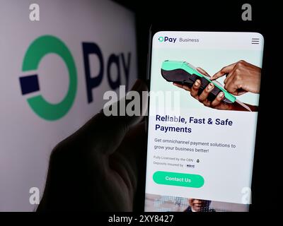 Person mit Smartphone und Webseite des nigerianischen Fintech-Unternehmens Opay Digital Services Limited mit Logo. Konzentrieren Sie sich auf die Mitte des Telefondisplays. Stockfoto