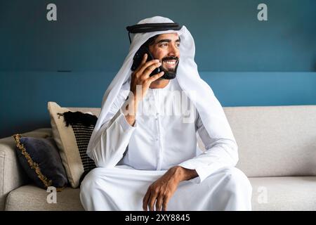 Arabischer Mann in traditioneller emiratischer Kleidung, der im Büro arbeitet - Porträt eines Geschäftsmannes aus dem Nahen Osten Stockfoto