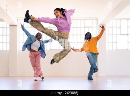 Junge Gruppe multiethnischer Hip-Hop-Tänzer in farbenfrohen urbanen Streetwear-Tänzen - stilvolles multirassisches Rap-Crew-Porträt im Tanzstudio Stockfoto