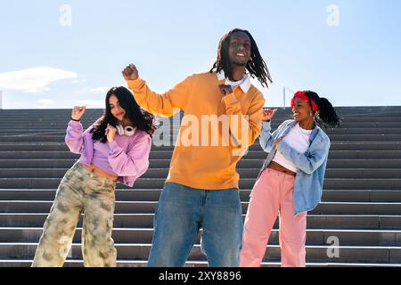 Junge Gruppe multiethnischer Hip-Hop-Tänzer in farbenfrohen urbanen Streetwear-Tänzen - stilvolles multirassisches Rap-Crew-Porträt in der Stadt Stockfoto