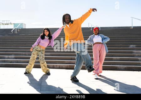 Junge Gruppe multiethnischer Hip-Hop-Tänzer in farbenfrohen urbanen Streetwear-Tänzen - stilvolles multirassisches Rap-Crew-Porträt in der Stadt Stockfoto