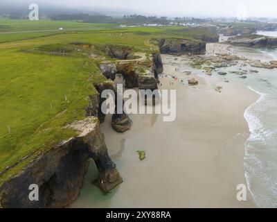 Aus der Vogelperspektive auf felsige Klippen und Bögen an einer subtropischen Küste mit grüner Vegetation und Sandstränden, aus der Vogelperspektive, Praia das Catedrais, Playa de las Stockfoto