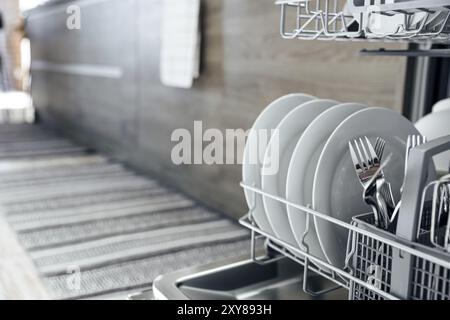 Nahaufnahme der geöffneten automatischen eingebauten Geschirrspülmaschine aus rostfreiem Edelstahl in der modernen Hausküche mit sauberem Utensilien. Haushalt, Haushalt, Haushalt, Haushalt Stockfoto