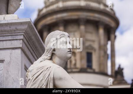 Weibliche Statue mit der französischen Kathedrale im Hintergrund Stockfoto