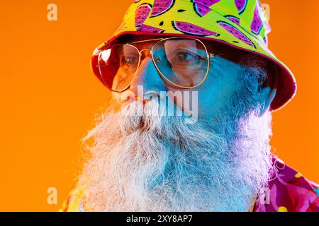 Seniorenreisender mit grauem Bart und tropischem Hemd Porträt im Studio - lustiger stylischer älterer männlicher Erwachsener mit coolem Stil, Konzepte über eld Stockfoto