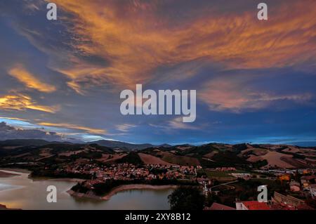 Paesaggio collinare Col paese di Mercatale affacciato sul lago, Sotto il cielo nuvoloso al tramonto Stockfoto