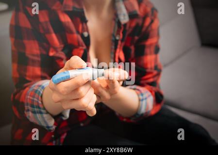 Nahaufnahme von Frauenhänden zur Messung des Glukosespiegels mit dem Glukometer Stockfoto