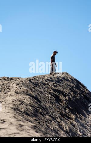 Junger Mann, der den Krater des Mount Bromo in Java, Indonesien, bewundert Stockfoto