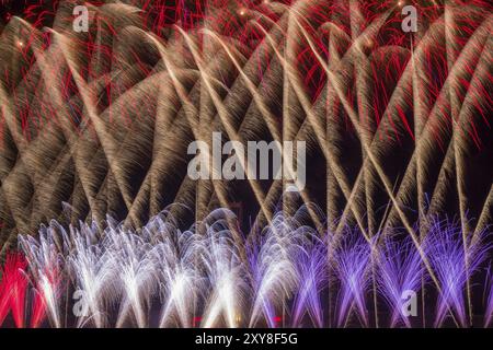 Leuchtendes Feuerwerk und Salut in verschiedenen Farben am Nachthimmel Stockfoto