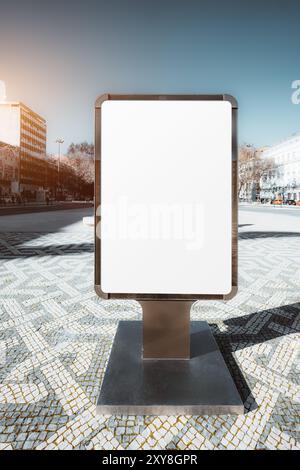Leere vertikale Reklametafeln mit leerer weißer Oberfläche in einem modernen urbanen Ambiente auf einem gemusterten Steinpflaster. Die Umgebung umfasst b Stockfoto