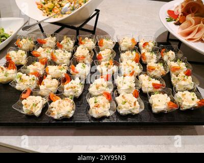 Die Auswahl an Snacks auf dem Buffettisch. Verschiedene leichte Snacks. Catering-Teller. Auswahl an Sandwiches auf dem Buffettisch, Fleisch, Süßigkeiten, Nüsse Stockfoto