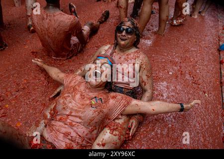 Valencia, Spanien. August 2024. Die Teilnehmer werden während des Tomatina-Festivals mit zerstoßenen Tomaten bedeckt. Wieder einmal fand das beliebte Festival La Tomatina in der valencianischen Stadt Buñol statt. Sechs Lkw mit 120.000 kg Tomaten wurden unter 22.000 Teilnehmern des Festivals geworfen. (Foto: David Canales/SOPA Images/SIPA USA) Credit: SIPA USA/Alamy Live News Stockfoto