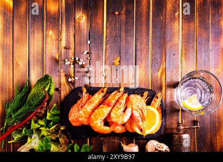 Gebratene Garnelen mit Knoblauch, Zitrone serviert auf schwarzem Teller Stockfoto