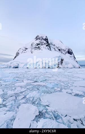 Blick auf die schneebedeckten Berge auf Booth Island, die die Westseite des Lemaire-Kanals in der Antarktis bilden. Stockfoto