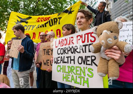London, Großbritannien. August 2024. Klimaaktivisten von Fossil Free London demonstrieren gegen die Labour-Partei, die den Ausbau des Flughafens London City außerhalb des Department for Levelling Up, Housing and Communities genehmigt. Anrede: Andrea Domeniconi/Alamy News Stockfoto