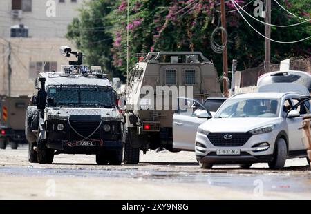 Jenin, Westjordanland. August 2024. Israelische Soldaten überprüfen die Dokumente eines Fahrers während eines Überfalls in Jenin im besetzten Westjordanland am Mittwoch, dem 28. August 2024. Am 28. August startete Israel eine Großoperation mit koordinierten Überfällen in vier Städten im nördlichen Westjordanland – Dschenin, Nablus, Tubas und Tulkarem. Foto: Nasser Ishtayeh/UPI Credit: UPI/Alamy Live News Stockfoto