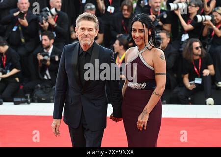 Venedig, Italien. August 2024. Willem Dafoe, Mitglied der Besetzung des Eröffnungsfilms, begleitet von seiner Frau Giada Colagrande, nimmt an der Eröffnung des 81. Internationalen Filmfestivals von Venedig mit dem Film „BeetleJuice BeetleJuice“ Teil. Quelle: Stefanie Rex/dpa/Alamy Live News Stockfoto