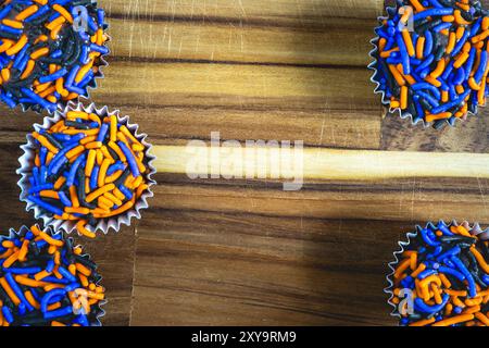 Typisch brasilianische Süßigkeiten, Brigadeiros. In Halloween-Farben, auf einem Holztisch. Süßigkeiten zu Halloween aus Brasilien. Stockfoto