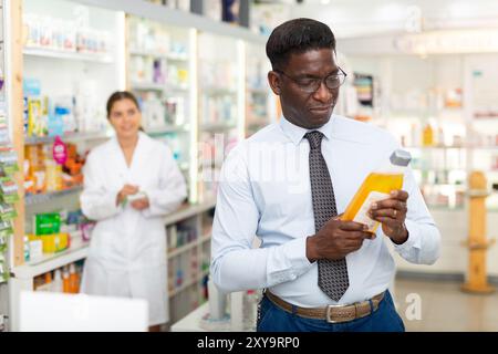 Mann hält Flasche mit Haarpflegeprodukt Stockfoto