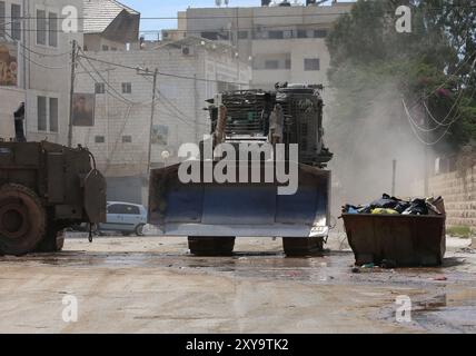 Jenin. August 2024. Israelische Militärfahrzeuge werden während einer israelischen Operation am 28. August 2024 in der Stadt Jenin im nördlichen Westjordanland gesehen. Mindestens 10 Palästinenser wurden am Mittwoch durch israelische Beschüsse und Schüsse im nördlichen Westjordanland getötet, so das palästinensische Gesundheitsministerium in Ramallah. Quelle: Nidal Eshtayeh/Xinhua/Alamy Live News Stockfoto