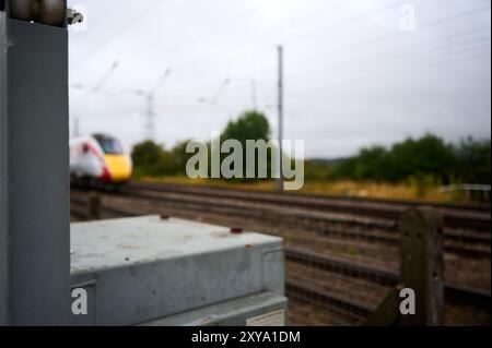 Bedfordshire UK - 24. august 2024 : verschwommenes Bild eines eingleisigen Hochgeschwindigkeits-LNER-Zuges auf einer viergleisigen Eisenbahn mit Überlandstromkabel Stockfoto