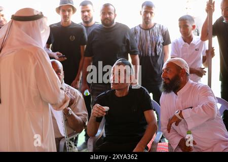 Rahat, Rahat im Süden Israels. August 2024. Die Geisel Qaid Farhan Alkadi (C, Front) wird von seinen Freunden und seiner Familie begrüßt, nachdem er am Dienstag in seinem Dorf in der Nähe von Rahat im Süden Israels am 28. August 2024 aus Gaza gerettet wurde. Das israelische Militär kündigte am Dienstag an, dass seine Truppen eine israelische Geisel aus einem unterirdischen Tunnel im südlichen Gazastreifen gerettet haben, als sie das Gebiet durchkämmten. Qaid Farhan Alkadi, 52, wurde allein in einem Tunnel gefunden, ohne Wachen oder andere Geiseln, sagte das Militär in einer Erklärung. Quelle: Jamal Awad/Xinhua/Alamy Live News Stockfoto