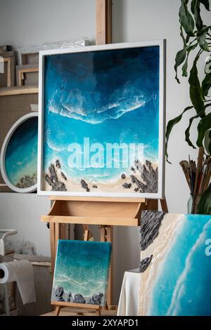 Fertige Kunstwerke aus Epoxidharz im Studio des Home Loft zeigen blaue Meereswellen und Küstenlinien. Heim-Business Stockfoto