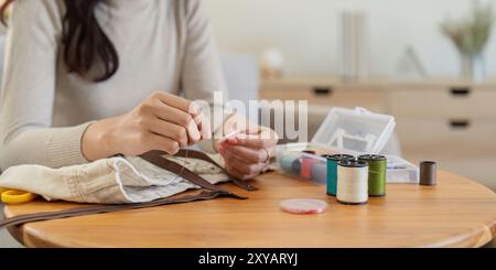 Frau repariert Stoff mit Nähset. Bastelkunst und Kreativität Stockfoto