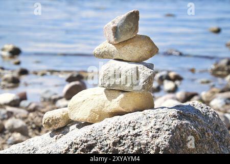 Steinpyramide an der Ostsee mit Blick auf das Meer mit blauem Himmel und Sonnenschein. Spirituelle Sichtweise. Landschaftsaufnahmen von Poel Island Stockfoto