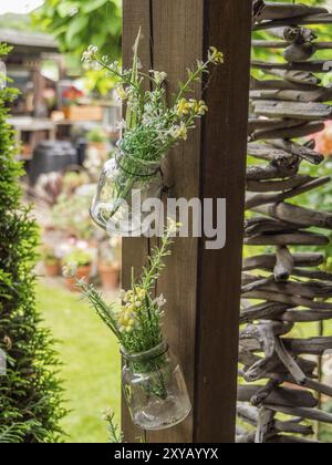 Zwei Einmachgläser mit Blumen auf einem Holzpfosten in einem Garten, borken, münsterland, deutschland Stockfoto