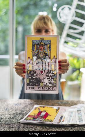 Nahaufnahme der Tarotkarte der Wagen, der vom Tarotleser in senkrechter Position gehalten wird Stockfoto