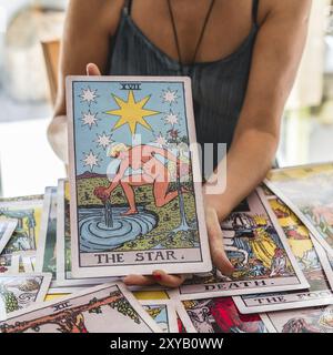 Nahaufnahme der riesigen Tarotkarte der Stern, die vom Tarotleser gehalten wird Stockfoto