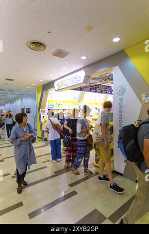 TOKIO, JAPAN, 21. JULI 2016: Mischung aus asiatischen und kaukasischen Touristen, die am Eingang des Pokemon Store des Narita Airport einkaufen. Vertikal Stockfoto