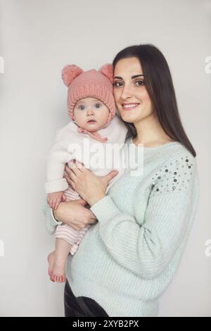 Mutter und Baby spielt und lächelnden, glücklichen Familie drinnen im Winter Stockfoto