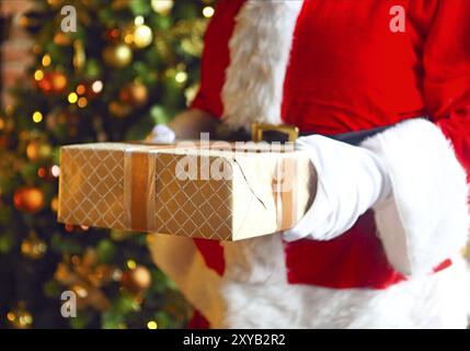 Santa Claus insgeheim anbringen Geschenkboxen unter den Weihnachtsbaum. Weihnachten Stockfoto