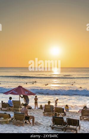 Surfer und Badende, Strand, Urlaub, Sonnenuntergang, Reisen, Strandurlaub, Tourismus, Abendsonne, Abendstimmung, entspannt, entspannen, Sonnenschirm, Sonnenschein, schön, Stockfoto