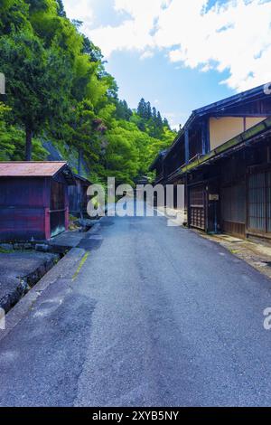 Wald auf der einen Seite, traditionelles Holzhaus auf der anderen Seite auf diesem Abschnitt des Nakasendo-Weges zwischen Magome-Tsumago in der Poststadt Tsumago, Japan auf A Stockfoto