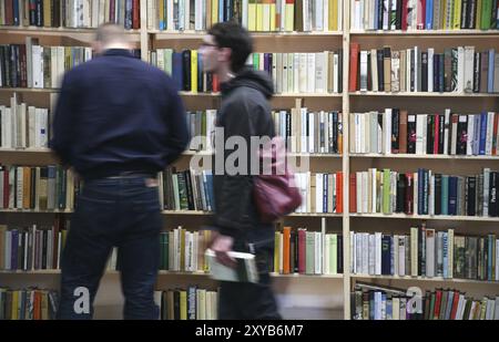 Leute vor vollen Bücherregalen Stockfoto